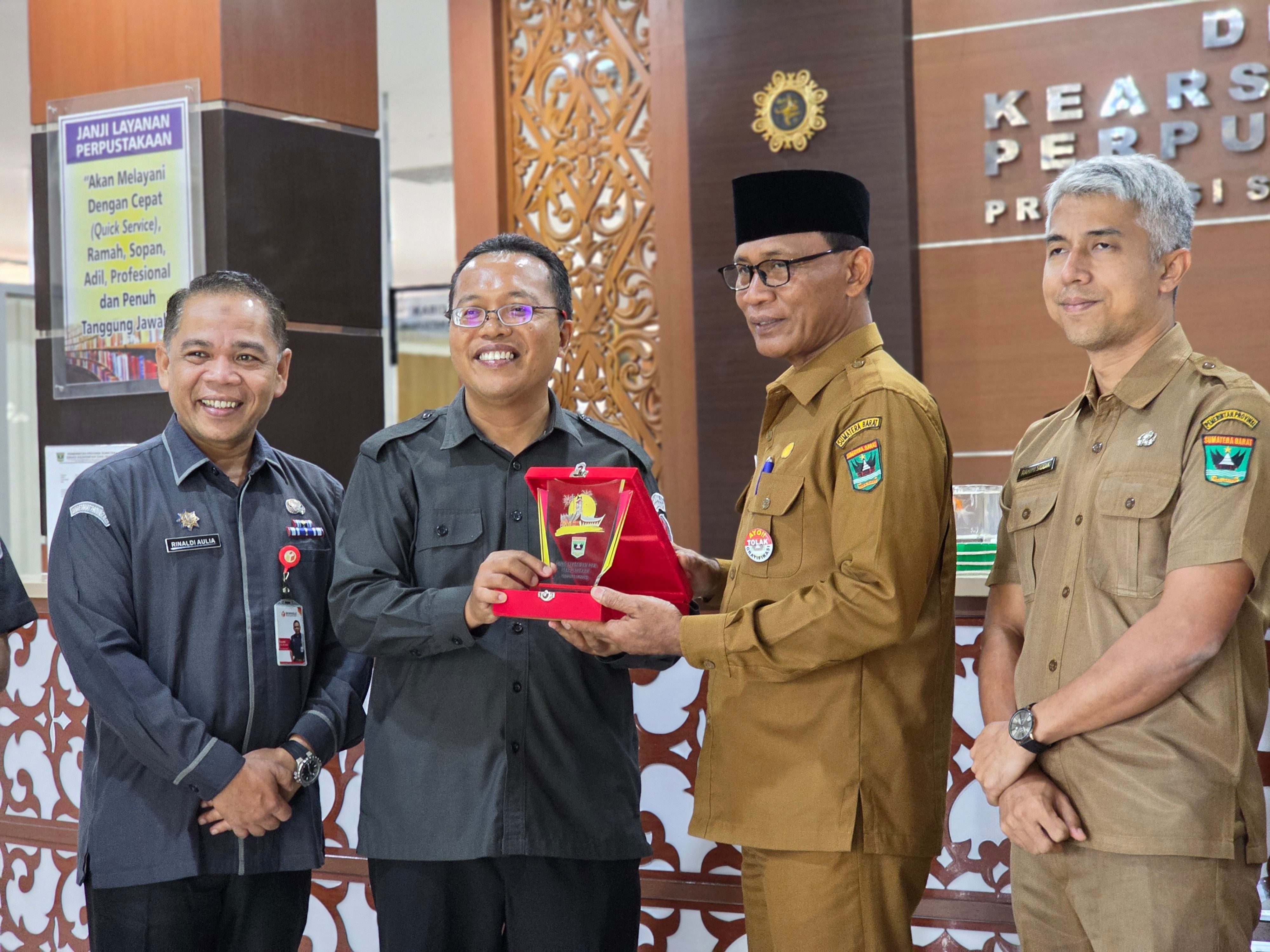 Penyerahan Cendera Mata Dinas Perpustakaan dan Kearsipan Provinsi Sumatera Barat kepada Ketua Bawaslu Provinsi Sumatera Barat, Selasa. 20/01/2026